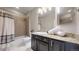 Updated bathroom with granite countertop and tiled shower/tub combo at 6931 Buckskin Dr, Littleton, CO 80125
