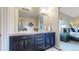 Double vanity bathroom with dark cabinetry and a large mirror at 6931 Buckskin Dr, Littleton, CO 80125