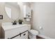 Stylish powder room featuring modern vanity with undermount sink, storage, and decorative mirror at 9579 Bighorn Way, Littleton, CO 80125