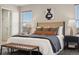Staged bedroom with a large bed, decorative pillows, and ample natural light from the windows at 9579 Bighorn Way, Littleton, CO 80125
