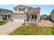 Charming two-story home features a manicured lawn, an attached two-car garage, and a covered front porch at 9579 Bighorn Way, Littleton, CO 80125