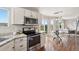 Bright kitchen with stainless appliances, stone counters, and an eat-in area that opens to the living room at 9579 Bighorn Way, Littleton, CO 80125
