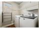 Well-organized laundry room with modern washer, dryer, wire shelving, and a window at 9579 Bighorn Way, Littleton, CO 80125
