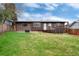 Expansive green backyard with brick home exterior, deck, and fire pit at 3150 S Pitkin St, Aurora, CO 80013