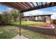 Charming backyard features a pergola, grassy area, and a brick retaining wall with garden beds at 3150 S Pitkin St, Aurora, CO 80013