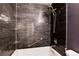 Stylish bathroom features dark tiling, shower with seat, and stainless steel grab bar at 3150 S Pitkin St, Aurora, CO 80013