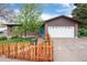 Charming brick home featuring a bright blue front door, fenced yard, and a two-car garage with an extended driveway at 3150 S Pitkin St, Aurora, CO 80013