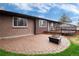 A brick patio extends to a tiered wooden deck with backyard views at 3150 S Pitkin St, Aurora, CO 80013