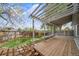 Well-maintained backyard featuring a wood pergola, grass, mature trees, and privacy fencing at 6398 S Emporia Cir, Englewood, CO 80111