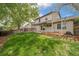 Lush backyard showing the lawn, covered patio with benches, mature trees, and privacy fence at 6398 S Emporia Cir, Englewood, CO 80111
