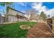 Expansive backyard boasts a fire pit, lush lawn, mature trees, and a mulch-lined path at 6398 S Emporia Cir, Englewood, CO 80111