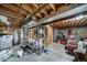 Unfinished basement space with exposed ceiling, utilities, shelving, and various stored items at 6398 S Emporia Cir, Englewood, CO 80111