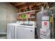 Basement laundry area includes washer, dryer, and water heater, plus utility shelving with cleaning supplies at 6398 S Emporia Cir, Englewood, CO 80111