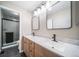 Bathroom features a double sink vanity with marble countertop and modern black fixtures, plus glass door shower at 6398 S Emporia Cir, Englewood, CO 80111