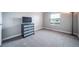 Bedroom with neutral walls and carpet, complemented by a window and dark dresser with a TV on top at 6398 S Emporia Cir, Englewood, CO 80111