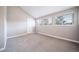 Bedroom with vaulted ceilings, neutral walls, carpeted floors, and three large windows at 6398 S Emporia Cir, Englewood, CO 80111