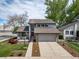 Inviting home with a neat lawn, brick features, two-car garage and cozy front porch seating area at 6398 S Emporia Cir, Englewood, CO 80111