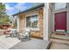 Relaxing front porch with seating area, brick accents, and a charming entryway at 6398 S Emporia Cir, Englewood, CO 80111
