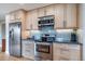 Well-equipped kitchen with stainless steel appliances, light wood cabinets, and blue tile backsplash at 6398 S Emporia Cir, Englewood, CO 80111