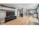 Open-concept living room featuring floating shelves and hardwood flooring flowing into the kitchen and dining areas at 6398 S Emporia Cir, Englewood, CO 80111