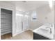 Bright bathroom featuring a walk-in shower with glass doors, double sinks, and built in linen storage at 2171 Peralta Loop, Castle Rock, CO 80104