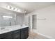 Bathroom featuring double sinks, modern fixtures, walk-in shower, and a view into the walk-in closet at 2171 Peralta Loop, Castle Rock, CO 80104