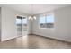Bright dining room featuring light hardwood floors, modern chandelier, and a sliding glass door with neighborhood views at 2171 Peralta Loop, Castle Rock, CO 80104
