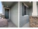 The covered front porch features stone accents, a gray door, and light gray siding at 2171 Peralta Loop, Castle Rock, CO 80104