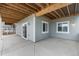 The covered patio features a gray privacy wall, windows, a sliding glass door, and concrete flooring at 2171 Peralta Loop, Castle Rock, CO 80104