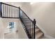 Carpeted staircase with dark wood railing and balusters, illuminated by natural light, ascending to the upper level at 2171 Peralta Loop, Castle Rock, CO 80104