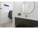 Modern bathroom with dark vanity and round mirror at 239 Rogers Ct, Castle Rock, CO 80104