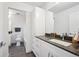 Modern bathroom featuring dark stone tile, granite countertops and plenty of storage space in the white cabinets at 5242 Columbine Ln, Denver, CO 80221