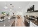 Well-lit kitchen featuring stainless steel appliances, island with sink, and adjacent dining area at 5242 Columbine Ln, Denver, CO 80221