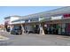 Retail storefronts with brick columns, large windows and clearly marked business signage under a long, white awning at 5242 Columbine Ln, Denver, CO 80221