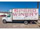 Speck Winery truck, artfully decorated, parked on gravel, offering unique wine experiences at 5242 Columbine Ln, Denver, CO 80221
