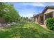 Spacious backyard with manicured lawn, landscaping and view of covered patio at 3380 Quail Ct, Wheat Ridge, CO 80033