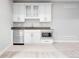 Basement wet bar with white cabinets, stainless steel microwave and beverage fridge, and neutral countertop at 3380 Quail Ct, Wheat Ridge, CO 80033