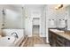 Full bathroom showcasing tub, separate shower, double vanity, and wood-look tile at 3380 Quail Ct, Wheat Ridge, CO 80033