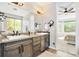 Bathroom with double vanity, large mirror, and view into a bedroom at 3380 Quail Ct, Wheat Ridge, CO 80033
