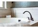 A close-up view of the bathtub featuring a luxurious faucet and neutral tile at 3380 Quail Ct, Wheat Ridge, CO 80033
