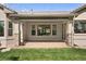 Covered patio area with stone pillars, large window, and views of the backyard at 3380 Quail Ct, Wheat Ridge, CO 80033