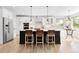 This spacious kitchen features a central island with barstool seating and modern pendant lighting at 3380 Quail Ct, Wheat Ridge, CO 80033
