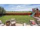 Inviting backyard featuring a manicured lawn, patio seating, and a charming play structure at 5338 Potentilla St, Brighton, CO 80601