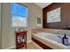 Bright bathroom featuring a soaking tub, tile accents, and a decorative white flower picture at 5338 Potentilla St, Brighton, CO 80601
