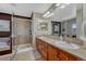 Bathroom featuring double sinks, vanity, walk-in shower with tile surround at 5338 Potentilla St, Brighton, CO 80601