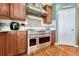 Close-up of a stainless steel range with a tile backsplash and wood cabinets at 5338 Potentilla St, Brighton, CO 80601