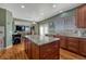 Bright kitchen with a large island, wood cabinets, and a view into the living area at 5338 Potentilla St, Brighton, CO 80601