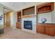 Cozy living room featuring a fireplace with tile surround and custom built-in cabinetry at 5338 Potentilla St, Brighton, CO 80601