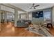 Open-concept living area with a large sectional sofa, hardwood floors, and a large-screen TV at 5338 Potentilla St, Brighton, CO 80601