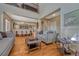 Spacious living room with high ceilings flowing into the dining area, and wood floors at 5338 Potentilla St, Brighton, CO 80601